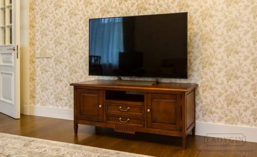 Деревянная тумба под телевизор во французском стиле с ящиками, дверками и открытой нишей в интерьере фото