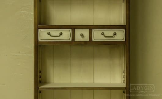 Белые выдвижные ящики с латунными ручками узкой высокой открытой библиотеки из массива дерева в стиле прованс фото