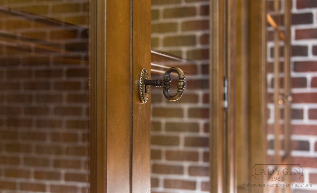 Ключ в замке деревянного встроенного кабинета в классическом французском стиле фото