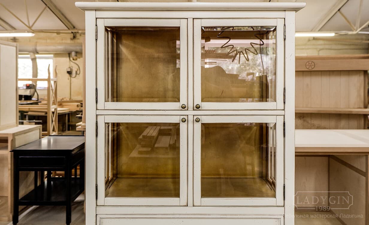 Стеклянные дверцы белой низкой витрины из массива дерева во французском стиле с 2 ящиками на ножках фото
