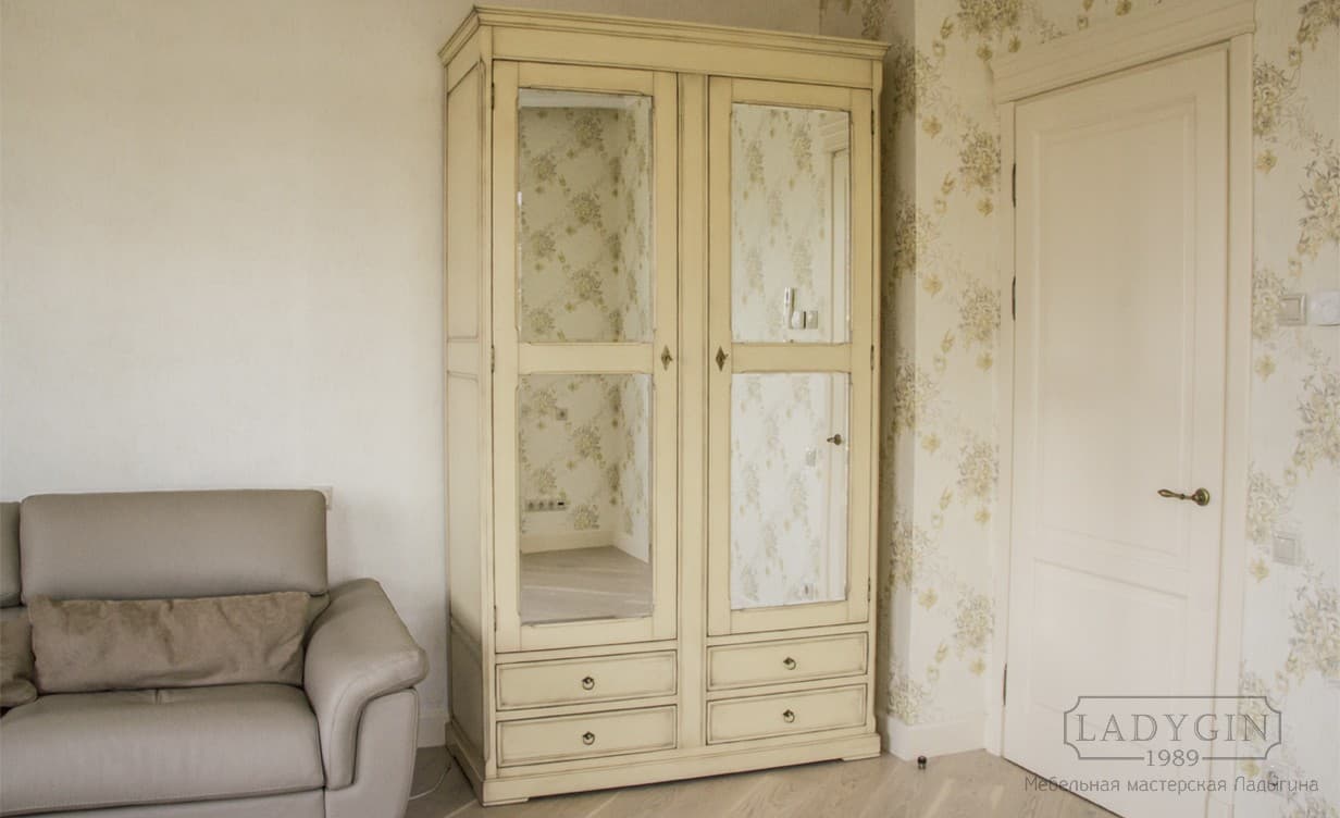 Белый платяной двухстворчатый шкаф в классическом стиле с 4 ящиками на подиуме в интерьере фото
