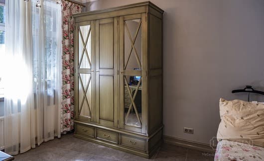 Платяной трехсекционный шкаф в стиле прованс с ящиками и зеркальными дверками в интерьере комнаты фото