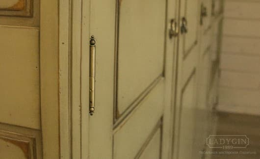 Петли белого платяного трехстворчатого шкафа из массива дерева в классическом стиле на цоколе в интерьере фото