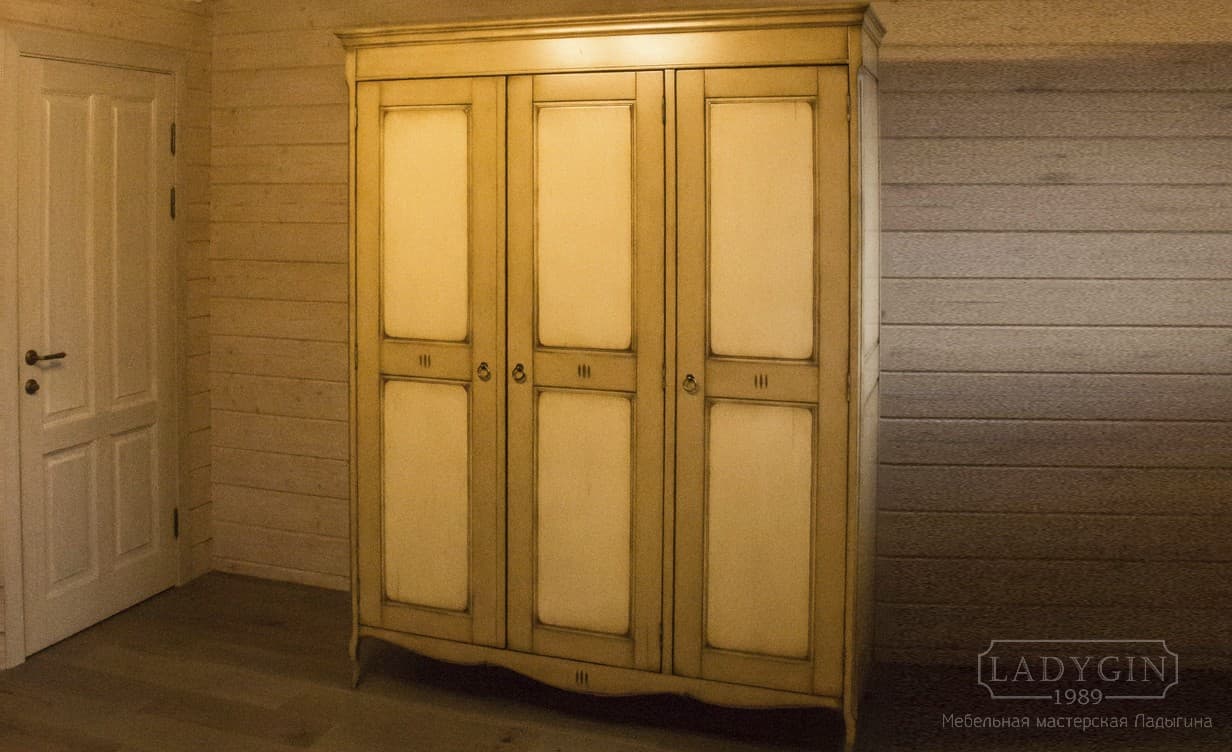Светлый платяной деревянный трёхстворчатый шкаф в стиле прованс на ножках в интерьере фото