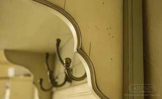 Резные элементы и крючки на узкой настенной вешалки с мягкой тумбой в стиле прованс фото