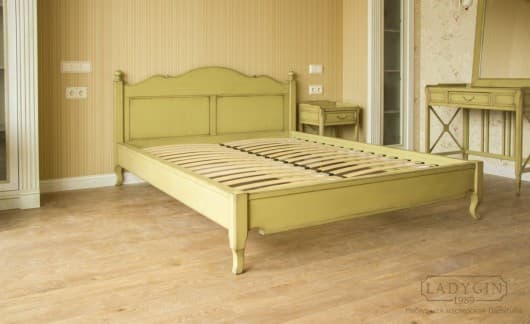 Жёлтая двуспальная кровать из массива дерева в стиле прованс с высоким резным изголовьем в интерьере спальни фото