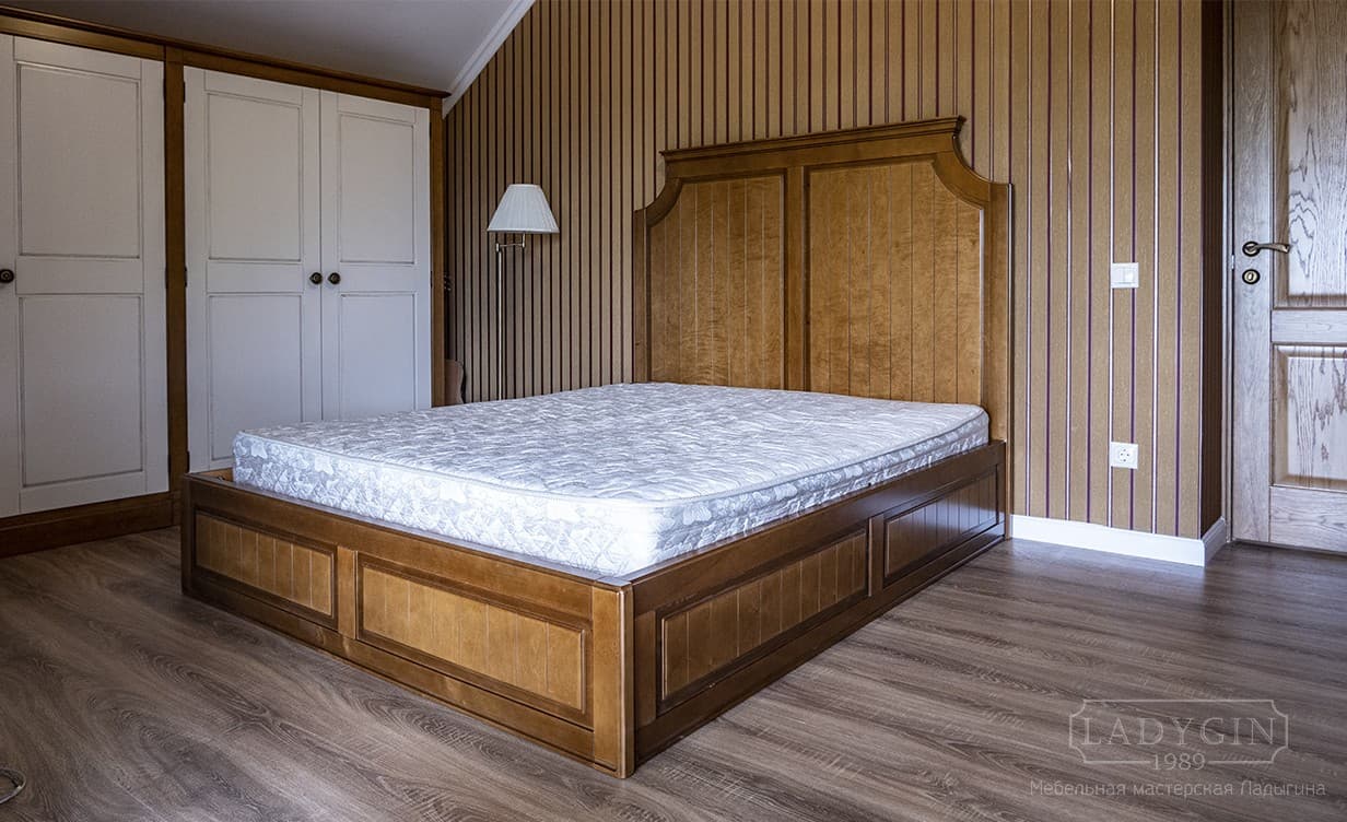Классическая деревянная двуспальная кровать в стиле прованс на подиуме с высоким изголовьем в интерьере спальни фото
