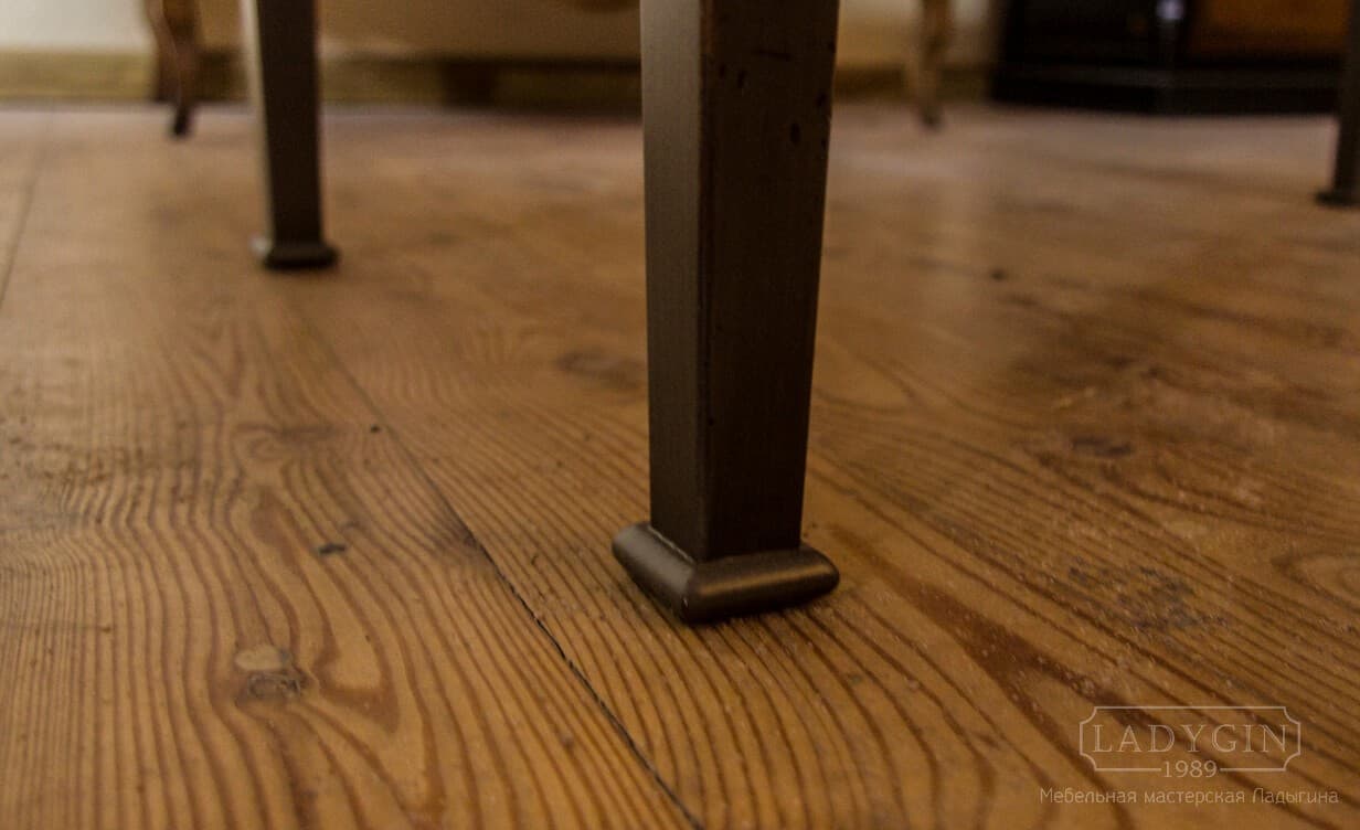 Резные ножки длинной деревянной банкетки с мягким сиденьем во французском стиле фото