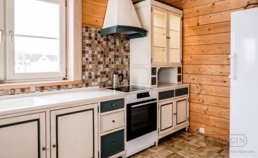 Бело-зелёная деревянная кухня во французском стиле со столешницей из искусственного камня и отлитой раковиной фото