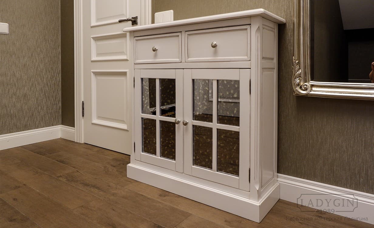 Белый двухстворчатый комод в классическом стиле с 2 ящиками и зеркальными дверками в интерьере фото