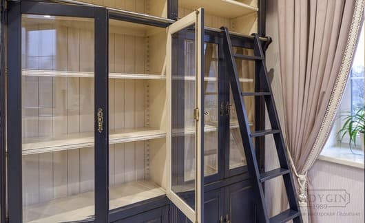 Белая внутренняя покраска синей модульной библиотеки из массива дерева в классическом французском стиле с лестницей и закрытыми секциями фото