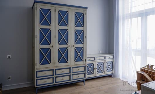 Бело-синий платяной трехсекционный шкаф из массива дерева в стиле 50-х с 6 ящиками в интерьере фото