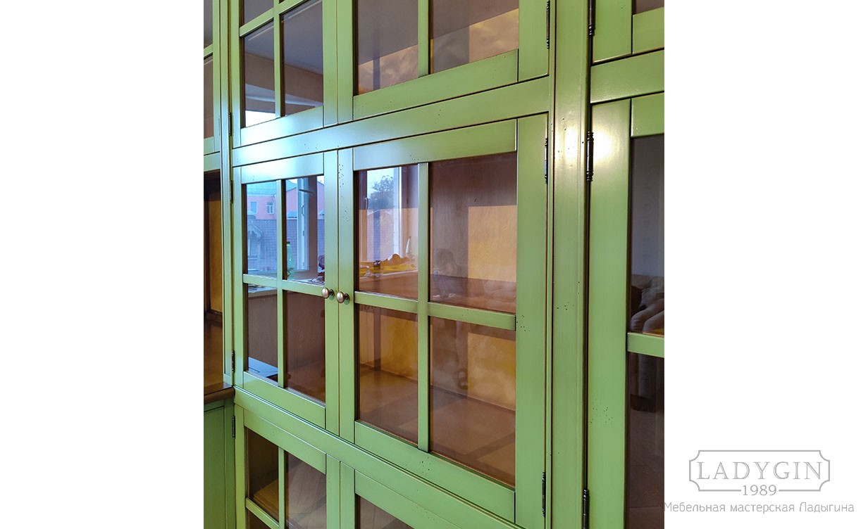 Перекрестия зелёной закрытой библиотеки из дерева в классическом стиле со стеклянными дверцами и рабочим местом фото