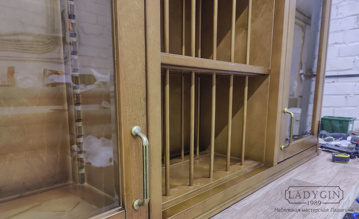 Ручки деревянного навесного шкафчика со стеклянными дверками в классическом стиле фото